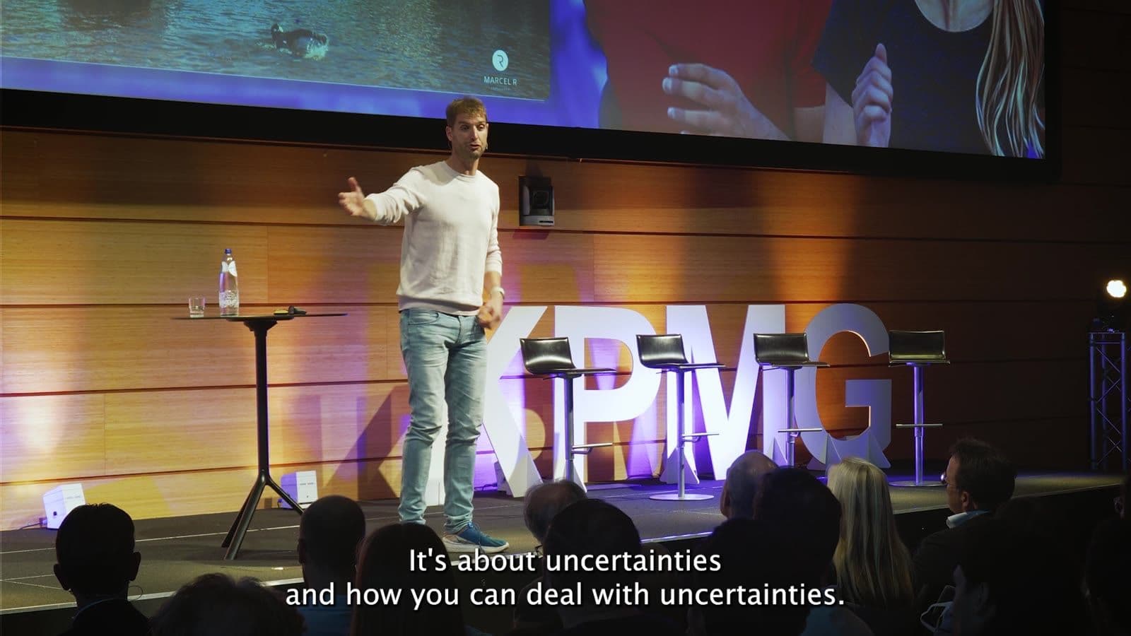 Maarten van der Weijden spreekt op het podium van een KPMG-event
