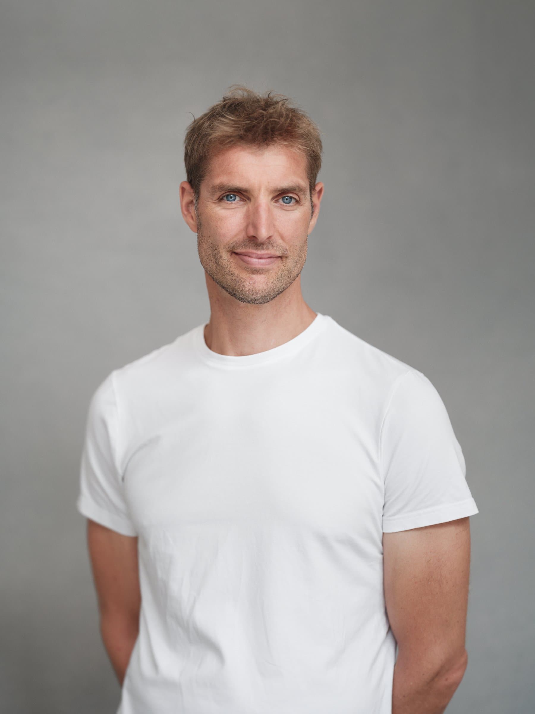 Portret van Maarten van der Weijden in een wit T-shirt voor een grijze achtergrond