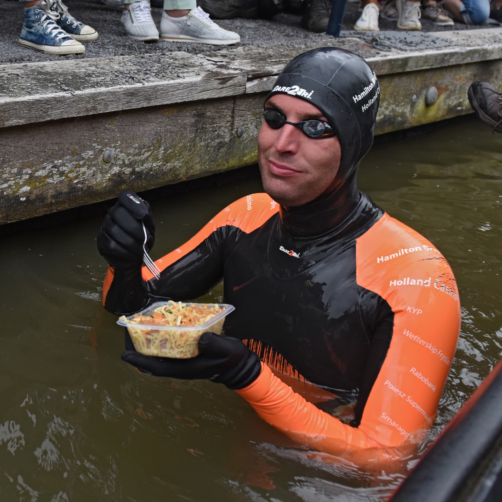 Maarten eet in het water uit een bakje, in wetsuit, tijdens zijn Elfstedentocht-poging in 2018